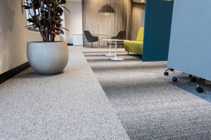 Office with contemporary decor and floor entirely covered by a smooth gray carpet.