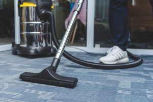 man cleaning the carpet flooring of an office